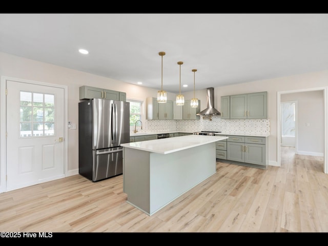 109 Inlet Ct, Hampstead, NC 28443 - kitchen with freestanding refrigerator, wall chimney exhaust hood, a sink, light countertops, and light wood-style flooring