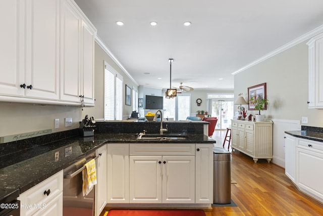 209 Georgia Ave, Carolina Beach, NC 28428 - kitchen with a sink, stainless steel dishwasher, a peninsula, ornamental molding, and white cabinets
