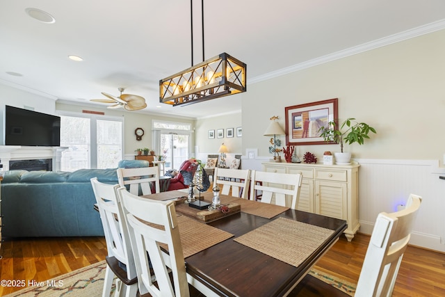 209 Georgia Ave, Carolina Beach, NC 28428 - dining area featuring ornamental molding, a ceiling fan, wood finished floors, wainscoting, and a fireplace