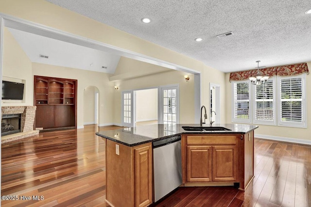 205 S Grist Mill Rd, Hampstead, NC 28443 - kitchen with dishwasher, a sink, open floor plan, a kitchen island with sink, and dark stone counters
