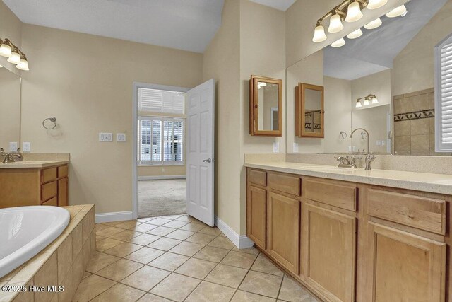 205 S Grist Mill Rd, Hampstead, NC 28443 - bathroom with tile patterned floors, two vanities, tiled tub, and baseboards