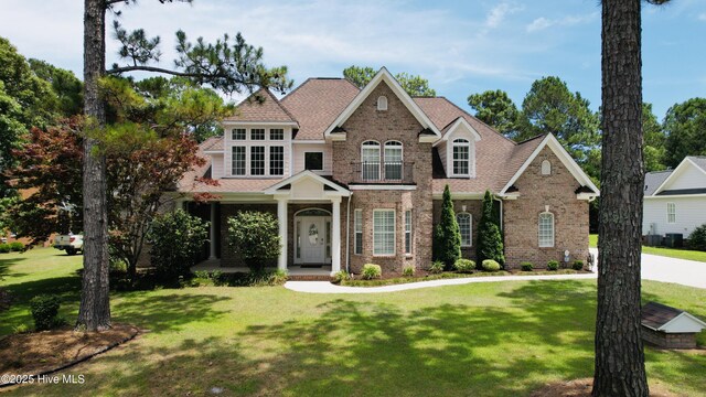 205 S Grist Mill Rd, Hampstead, NC 28443 - view of front of house featuring brick siding, a front lawn, a porch, and a shingled roof