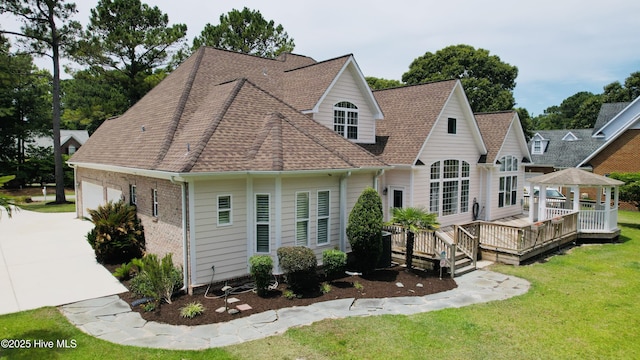 205 S Grist Mill Rd, Hampstead, NC 28443 - back of property with a lawn, a garage, a gazebo, a deck, and a shingled roof