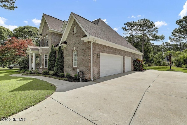 205 S Grist Mill Rd, Hampstead, NC 28443 - view of side of property featuring concrete driveway, brick siding, a yard, a balcony, and roof with shingles