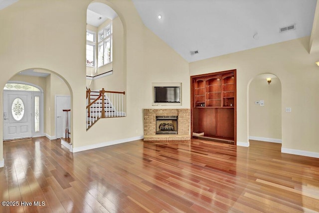 205 S Grist Mill Rd, Hampstead, NC 28443 - unfurnished living room featuring high vaulted ceiling, arched walkways, stairway, and plenty of natural light