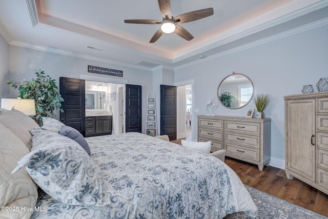 232 Trawlers Way, Wilmington, NC 28412 - bedroom featuring a tray ceiling, dark wood finished floors, connected bathroom, ceiling fan, and crown molding