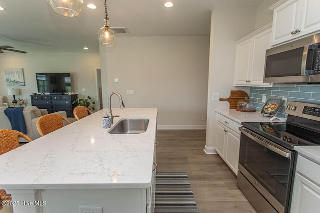 873 Bourne Dr SW, Ocean Isle Beach, NC 28469 - kitchen featuring stainless steel appliances, a sink, decorative backsplash, white cabinetry, and open floor plan