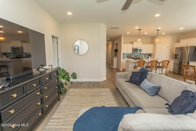 873 Bourne Dr SW, Ocean Isle Beach, NC 28469 - living area with light wood finished floors, ceiling fan, baseboards, and recessed lighting