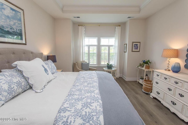 873 Bourne Dr SW, Ocean Isle Beach, NC 28469 - bedroom featuring a tray ceiling, dark wood-style flooring, ornamental molding, and baseboards