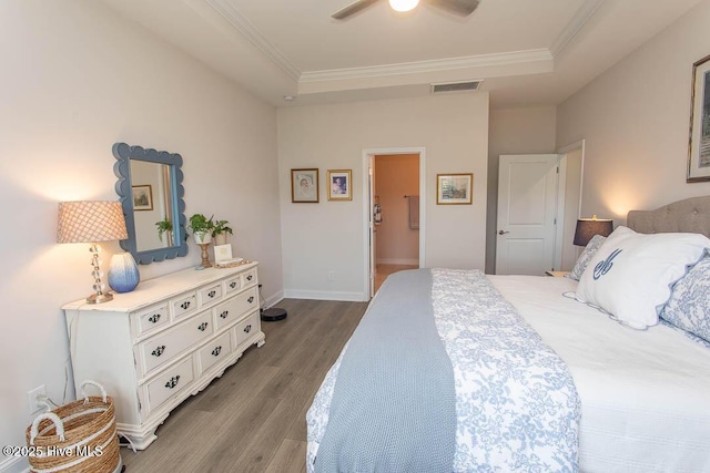 873 Bourne Dr SW, Ocean Isle Beach, NC 28469 - bedroom with wood finished floors, crown molding, a tray ceiling, ceiling fan, and baseboards