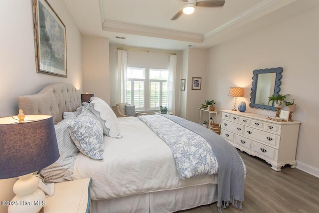 873 Bourne Dr SW, Ocean Isle Beach, NC 28469 - bedroom featuring a raised ceiling, wood finished floors, crown molding, baseboards, and a ceiling fan