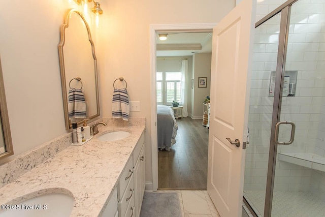 873 Bourne Dr SW, Ocean Isle Beach, NC 28469 - ensuite bathroom featuring double vanity, a shower stall, and wood finished floors