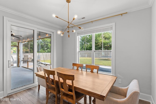 386 Yucca Ln, Wilmington, NC 28412 - dining room with crown molding, a chandelier, light wood-style flooring, and baseboards