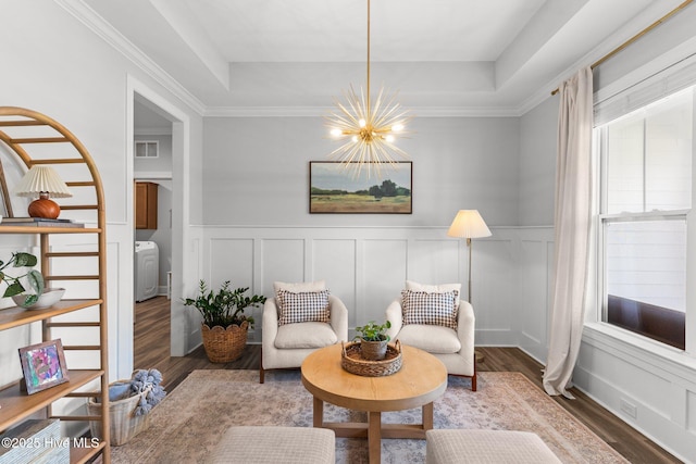 386 Yucca Ln, Wilmington, NC 28412 - living area featuring a chandelier, a raised ceiling, wood finished floors, a decorative wall, and a wainscoted wall