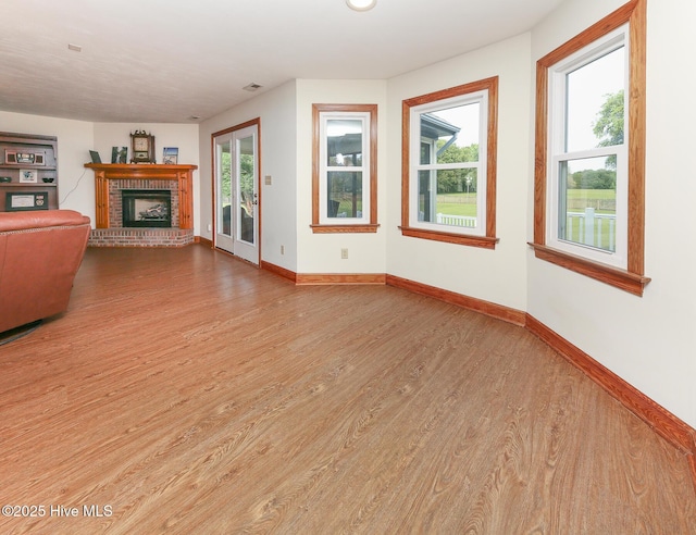 813 Puddin Ridge Rd, Moyock, NC 27958 - unfurnished living room with wood finished floors, a brick fireplace, and baseboards