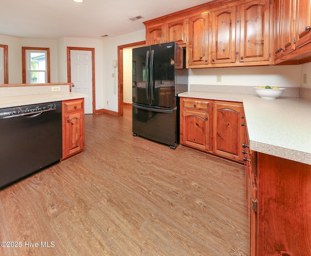 813 Puddin Ridge Rd, Moyock, NC 27958 - kitchen featuring black appliances, light wood-type flooring, light countertops, brown cabinets, and baseboards