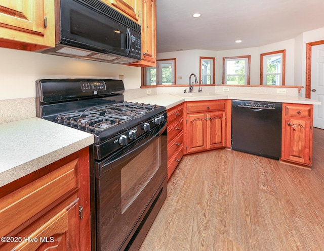 813 Puddin Ridge Rd, Moyock, NC 27958 - kitchen with black appliances, a sink, light wood-style floors, light countertops, and recessed lighting
