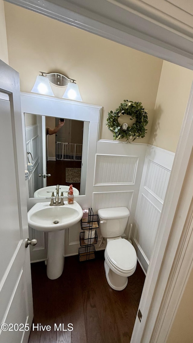 308 E Dolphin Vw, Sneads Ferry, NC 28460 - bathroom with toilet, wood finished floors, wainscoting, and a decorative wall