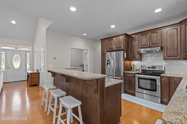 103 Sandspur Ln, West End, NC 27376 - kitchen featuring appliances with stainless steel finishes, under cabinet range hood, light wood-type flooring, a breakfast bar, and recessed lighting
