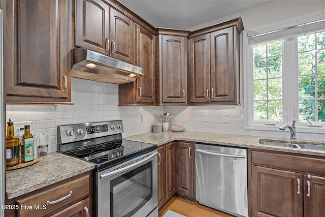 103 Sandspur Ln, West End, NC 27376 - kitchen with appliances with stainless steel finishes, under cabinet range hood, plenty of natural light, and light stone countertops