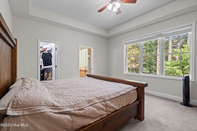 103 Sandspur Ln, West End, NC 27376 - bedroom with light colored carpet, a tray ceiling, baseboards, a walk in closet, and a closet