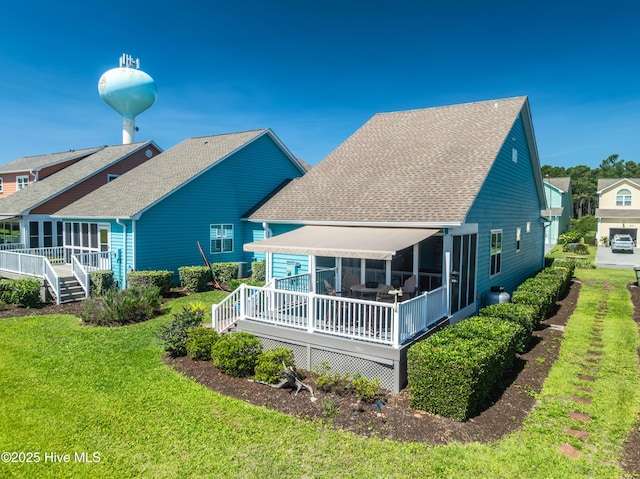632 Settlers Ln, Kure Beach, NC 28449 - back of property with a deck, a shingled roof, and a lawn