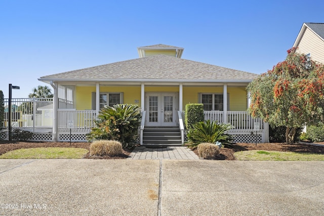 632 Settlers Ln, Kure Beach, NC 28449 - view of front facade featuring covered porch, french doors, and roof with shingles