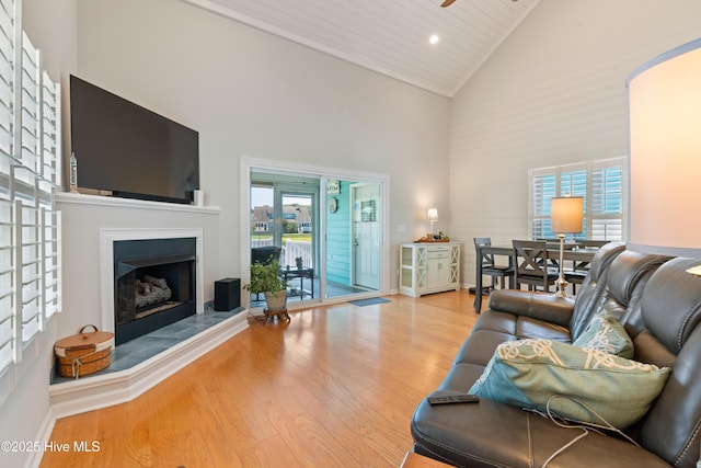 632 Settlers Ln, Kure Beach, NC 28449 - living area with high vaulted ceiling, wood finished floors, a fireplace with raised hearth, ceiling fan, and recessed lighting
