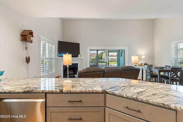 632 Settlers Ln, Kure Beach, NC 28449 - kitchen with stainless steel dishwasher, open floor plan, light stone counters, and a towering ceiling