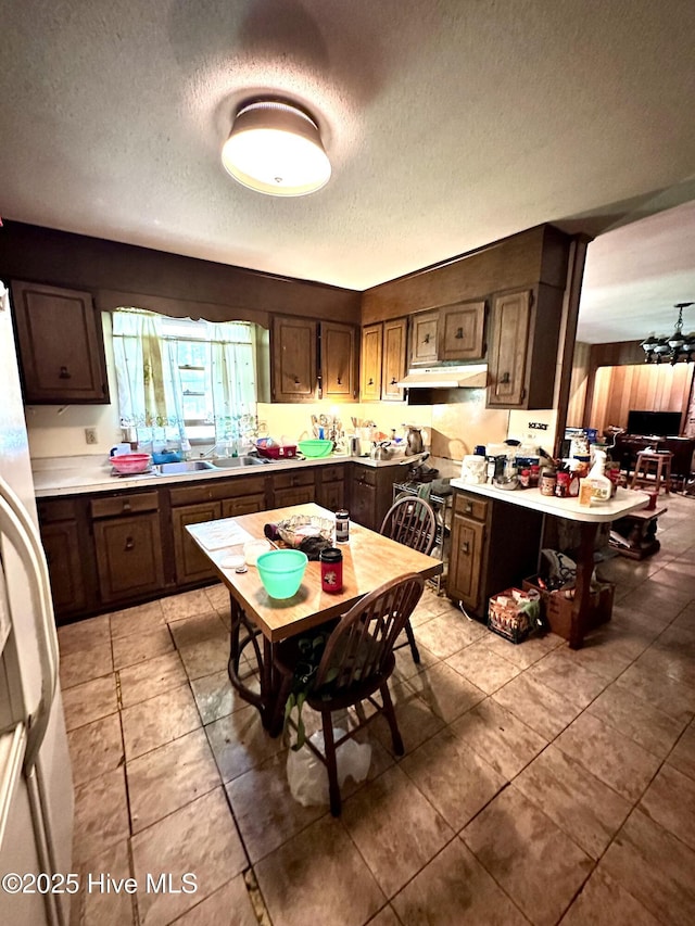 2513 David Ave, Kinston, NC 28501 - kitchen featuring under cabinet range hood, a textured ceiling, freestanding refrigerator, light countertops, and light tile patterned floors