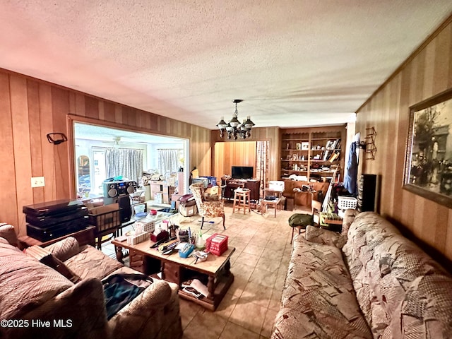 2513 David Ave, Kinston, NC 28501 - living room featuring a textured ceiling, a chandelier, wooden walls, and tile patterned flooring