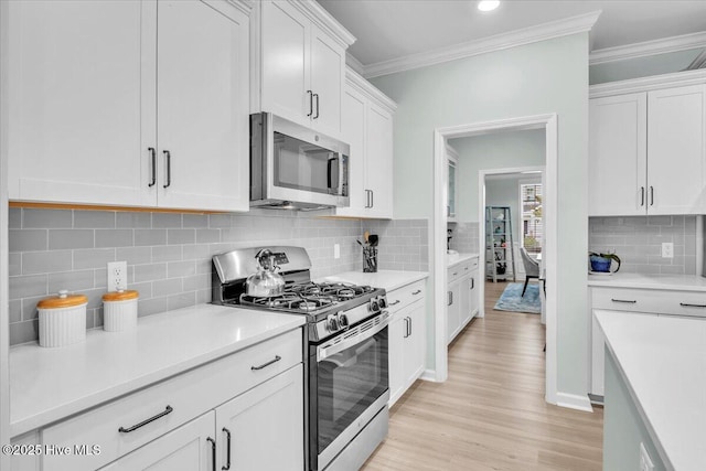 1233 Lt Congleton Rd, Wilmington, NC 28409 - kitchen with stainless steel appliances, backsplash, white cabinets, light wood finished floors, and light countertops