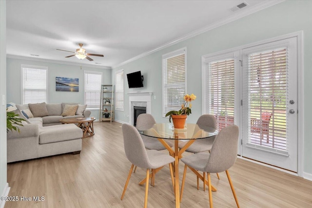 1233 Lt Congleton Rd, Wilmington, NC 28409 - dining area featuring light wood-style floors, ceiling fan, ornamental molding, a fireplace, and baseboards