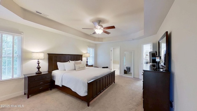 2019 Royal Pines Dr, New Bern, NC 28560 - bedroom with light carpet, a tray ceiling, baseboards, and ensuite bath