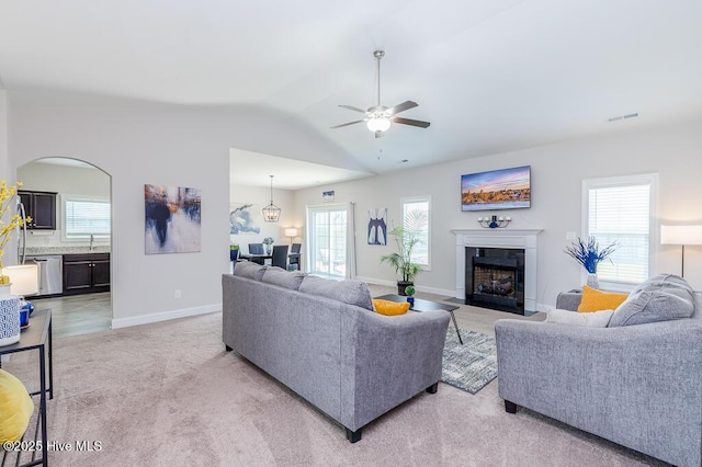 1000 Spot Cir, New Bern, NC 28562 - living area featuring ceiling fan, a fireplace with flush hearth, light carpet, plenty of natural light, and vaulted ceiling