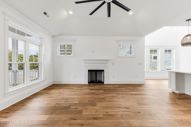 1605 E Oak Island Dr, Oak Island, NC 28465 - unfurnished living room with plenty of natural light, lofted ceiling, ceiling fan, a high end fireplace, and light wood-style flooring