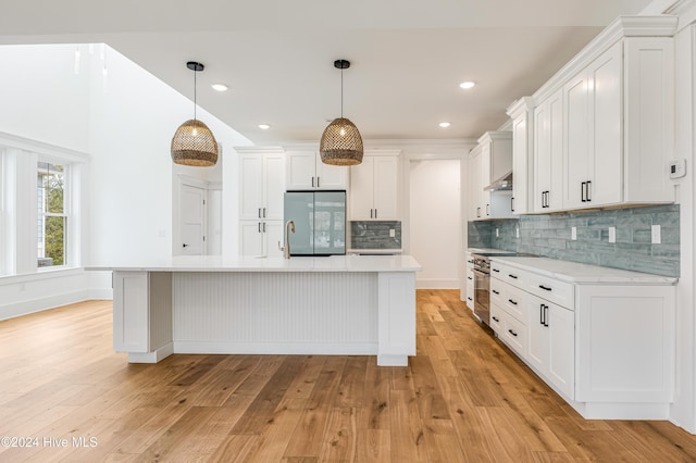 1605 E Oak Island Dr, Oak Island, NC 28465 - kitchen featuring refrigerator, light countertops, stainless steel range oven, light wood-style flooring, and white cabinets