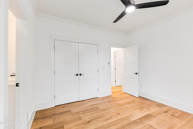 1605 E Oak Island Dr, Oak Island, NC 28465 - unfurnished bedroom with crown molding, light wood-style floors, a closet, ceiling fan, and baseboards
