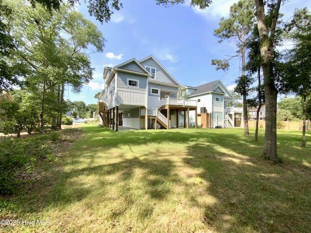 1605 E Oak Island Dr, Oak Island, NC 28465 - rear view of house featuring stairway, a yard, and a deck