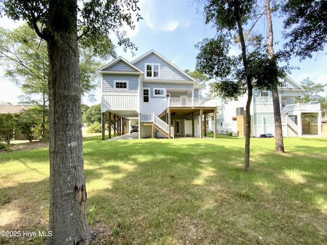 1605 E Oak Island Dr, Oak Island, NC 28465 - rear view of property featuring stairs and a lawn
