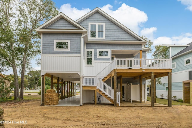 1605 E Oak Island Dr, Oak Island, NC 28465 - rear view of property featuring a carport, stairs, a deck, dirt driveway, and a patio