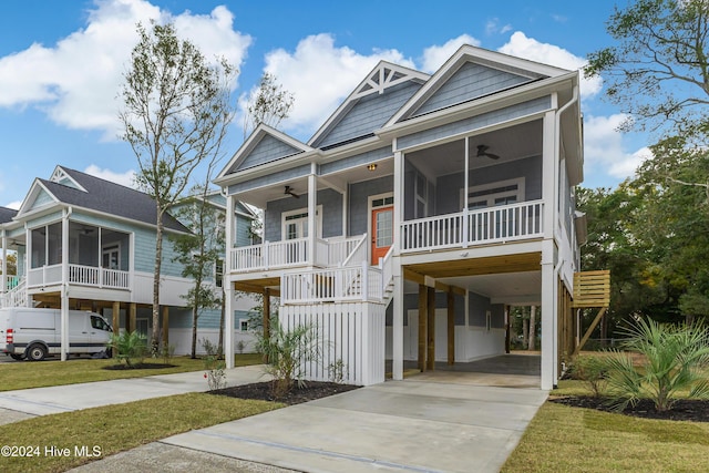 1605 E Oak Island Dr, Oak Island, NC 28465 - coastal inspired home with ceiling fan, a carport, a sunroom, stairs, and driveway