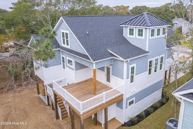 1605 E Oak Island Dr, Oak Island, NC 28465 - rear view of property featuring a shingled roof, a wooden deck, and cooling unit