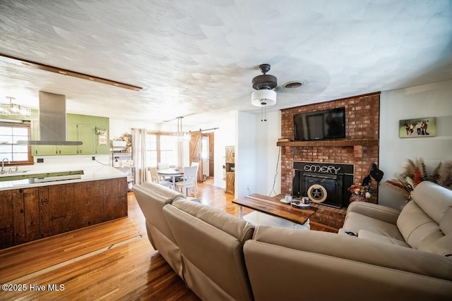 10179 NC Highway 305, Jackson, NC 27845 - living area featuring a fireplace, light wood finished floors, and a ceiling fan