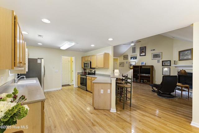 3863 Daphine Ct, Wilmington, NC 28409 - kitchen featuring stainless steel appliances, a sink, a breakfast bar area, light wood finished floors, and light brown cabinets