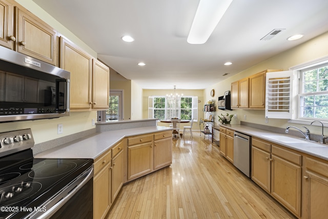 3863 Daphine Ct, Wilmington, NC 28409 - kitchen featuring stainless steel appliances, a chandelier, a sink, light wood-style flooring, and light countertops