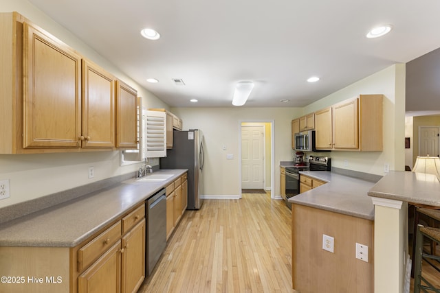 3863 Daphine Ct, Wilmington, NC 28409 - kitchen with appliances with stainless steel finishes, a sink, baseboards, light wood-type flooring, and a peninsula