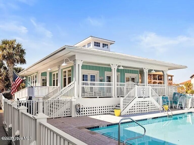 1523 Island Marina Dr, Carolina Beach, NC 28428 - back of house with stairway, a community pool, and a porch