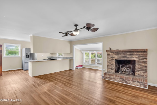 214 Frink Dr, Southport, NC 28461 - unfurnished living room with crown molding, wood finished floors, a ceiling fan, a fireplace, and baseboards