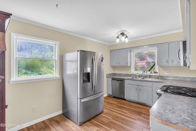 214 Frink Dr, Southport, NC 28461 - kitchen featuring stainless steel appliances, a sink, crown molding, light wood finished floors, and baseboards
